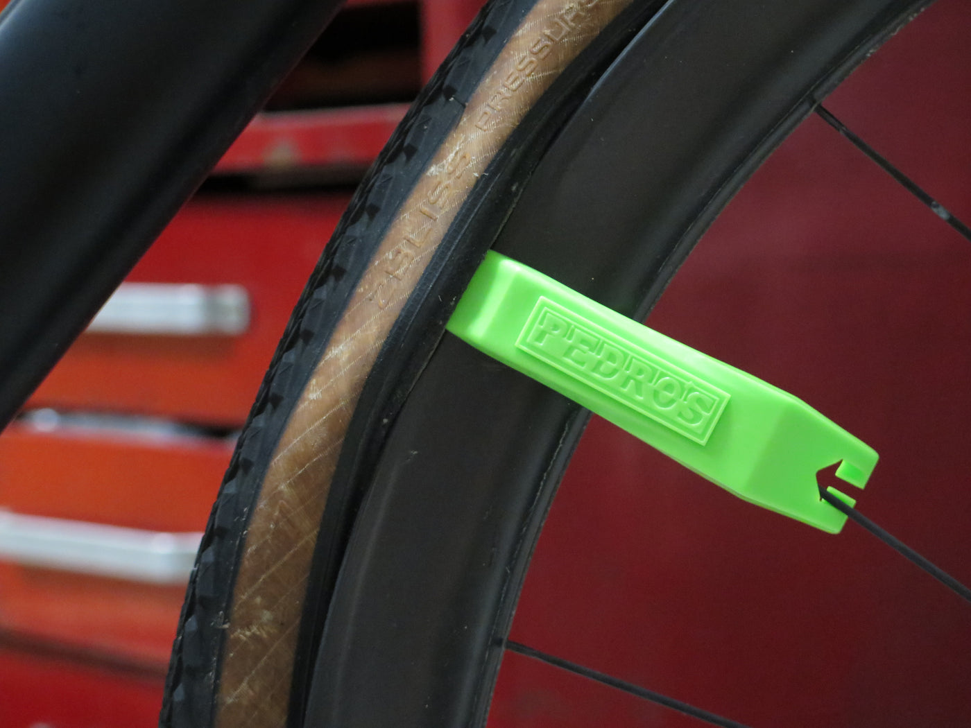 pedro's tyre lever spoke hooks being used to hold the tyre lever onto an enve carbon wheel