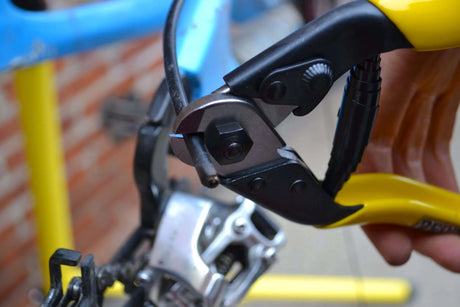 Close up of Pedro's cable cutter being used to cut bicycle shift outer cable near the rear derailleur