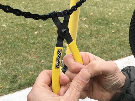 Pedro's Master/Quick Link Pliers being used to break a chain link in a garden.