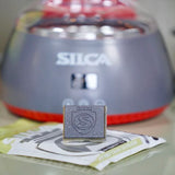 A single silca strip chip on a benchtop in front of Silca's chain waxing system.